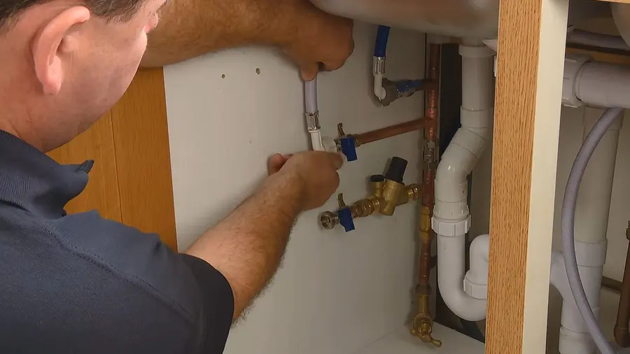 Water softener tank, control valve, and service connections during a plumbing service visit in West Altadena